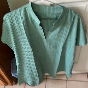 A muted green V neck top.  Polyester material. Ordered wrong size. Will reorder.